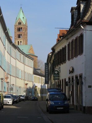 A street with historic buildings, a church tower, and parked cars. - Hotel Trutzpfaff (Speyer)