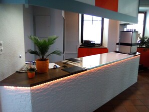 A reception desk with a potted plant, a laptop, and a telephone. - Hotel Trutzpfaff (Speyer)