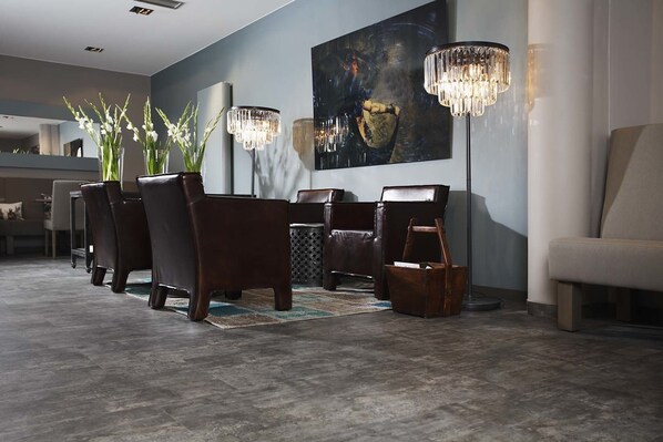 Un espace repas moderne avec des chaises en bois foncé, une table centrale et deux lampadaires.