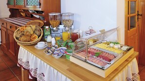 A breakfast buffet with various food items, including bread, cereals, and meats. - Gaestehaus Vogl (Berchtesgaden)