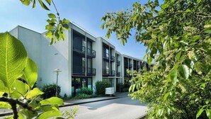 A modern building with multiple floors, large windows, and a sign indicating it is a hotel. - Bildungs- und Tagungshaus Haus Neuland (Bielefeld)