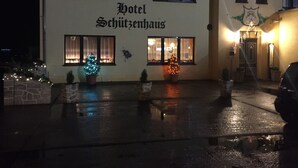 A building with the sign "Hotel Schutzhaus" at night.