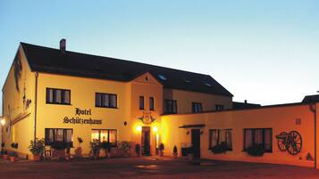 Vista frontal de la propiedad por la tarde o noche