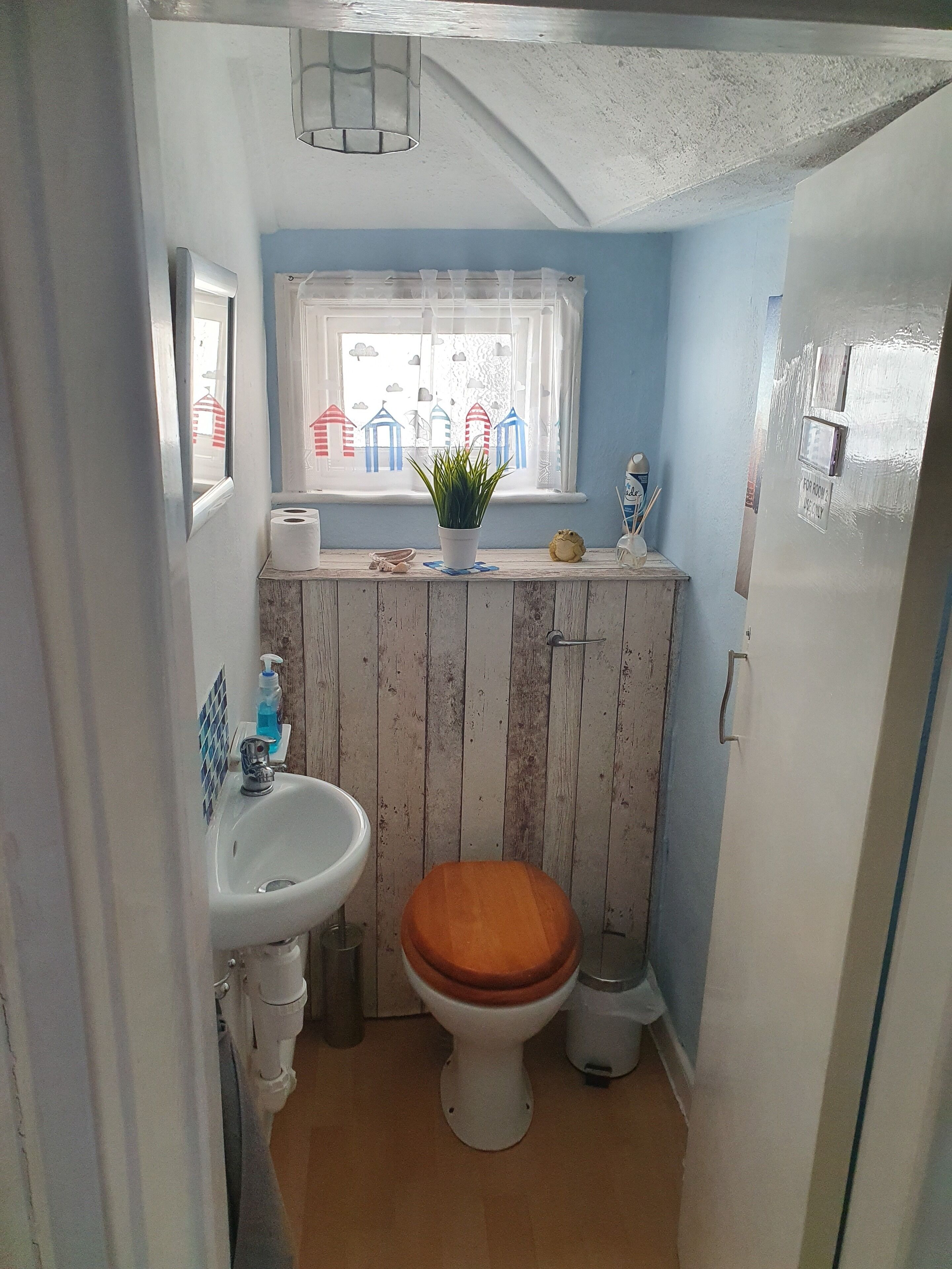 Un baño pequeño con inodoro, lavamanos y ventana.