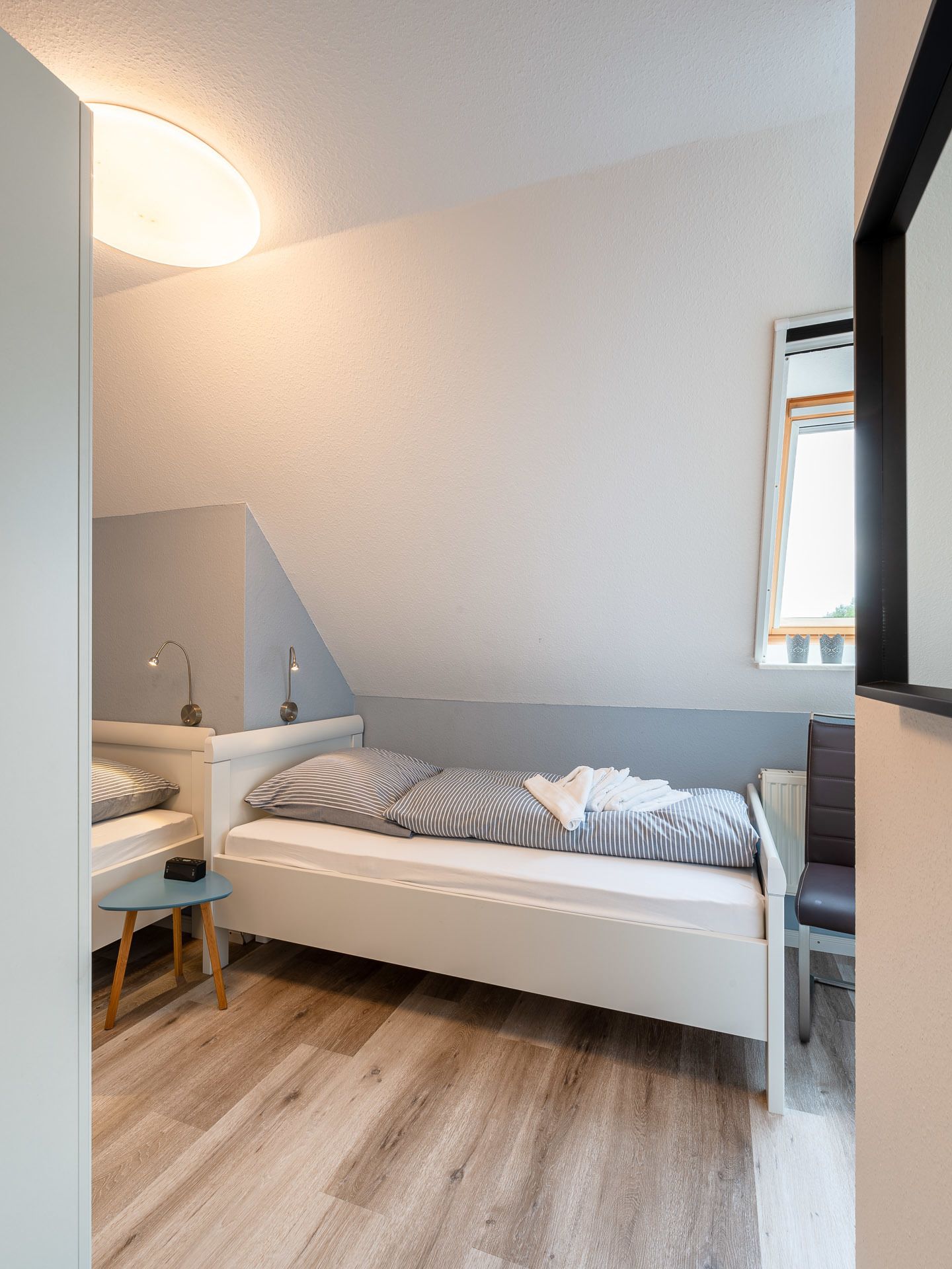 Quarto moderno com cama beliche, uma mesinha e uma cadeira.