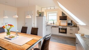 A modern kitchen with a built-in oven, microwave, and a window above the sink. - Haus Bendix (Dagebuell)