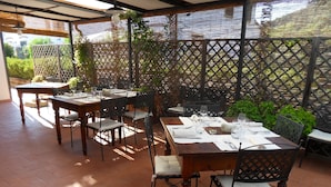 Eine Außenpatio mit Holztischen und -stühlen, bereit zum Essen.