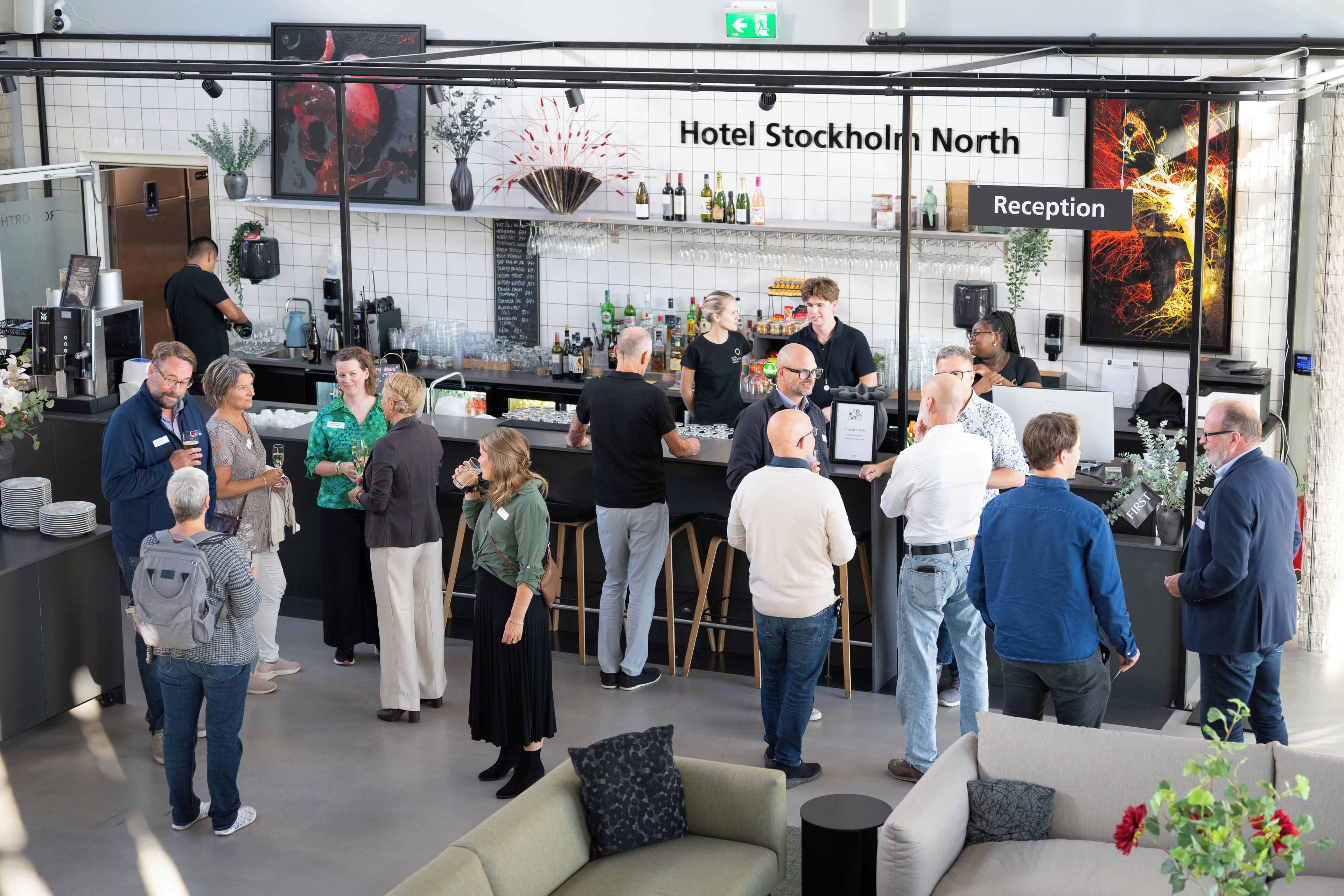 A reception area with a sign for 'Hotel Stockholm North' and a bar area with various bottles and glasses.