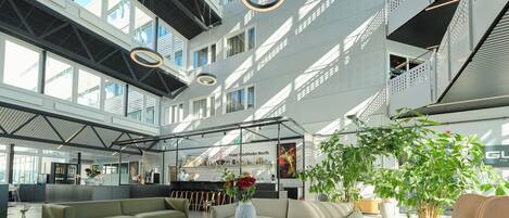 Un hall amplio con techos altos, ventanas grandes y mobiliario moderno.