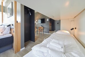 Una habitación de hotel moderna con una cama grande, un escritorio y una televisión.