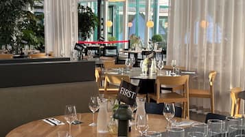 Un restaurant avec des tables rondes, des chaises et une pancarte indiquant « PREMIER » sur chaque table.