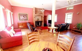 Una sala de estar con chimenea, sofá, mesa de comedor y televisor.