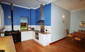 Una cocina moderna con estufa, horno, microondas y una chimenea grande.