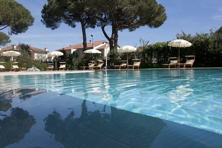 Una piscina al aire libre, sillones reclinables de piscina