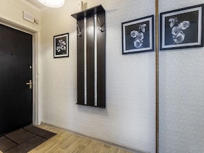 Stylish hallway with framed photographs and a door leading to a room.
