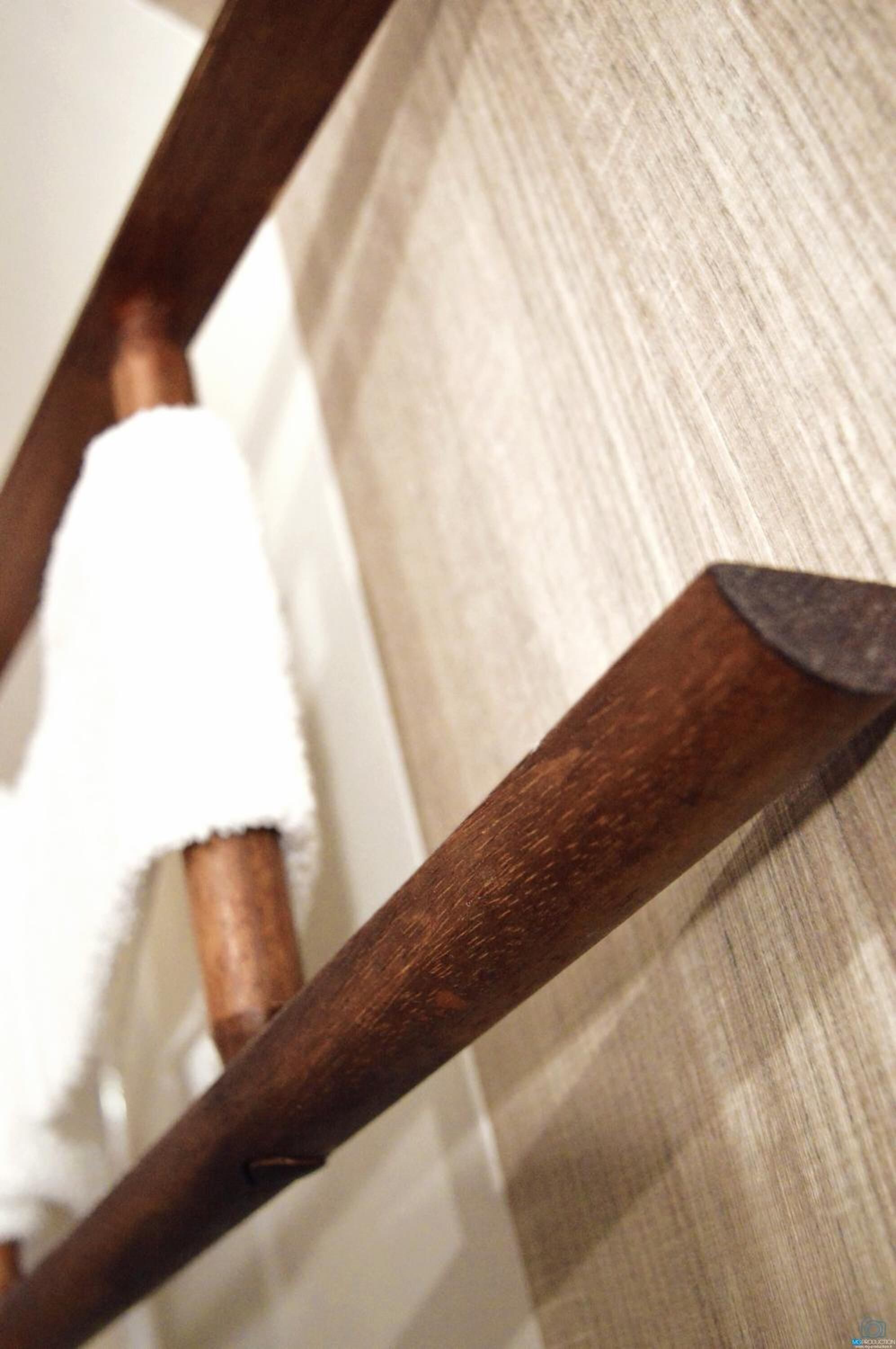 Primer plano de una silla de madera con un cojín blanco.