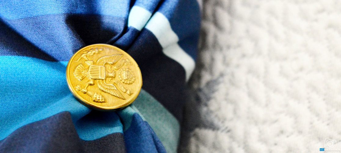 A gold coin with intricate designs on a fabric background.