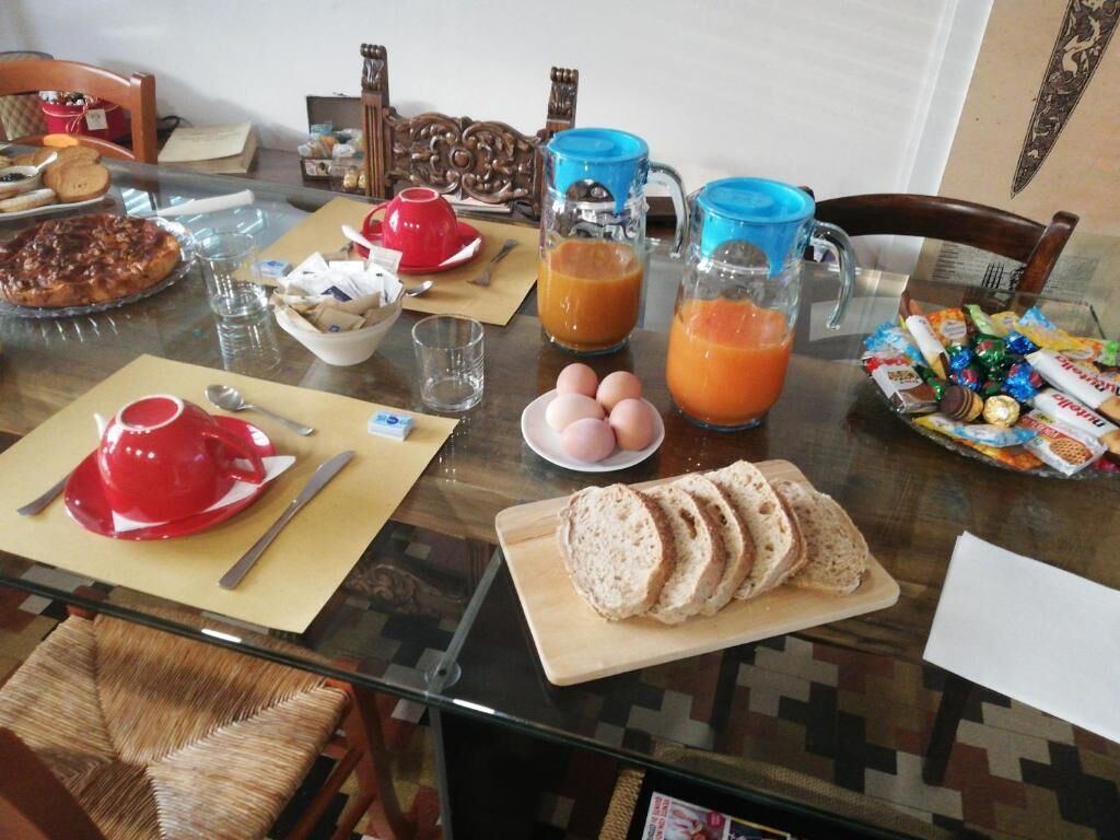 A dining table with breakfast items including eggs, bread, and juice.