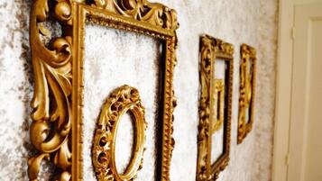 Ornate gold-framed mirrors on a textured wall.