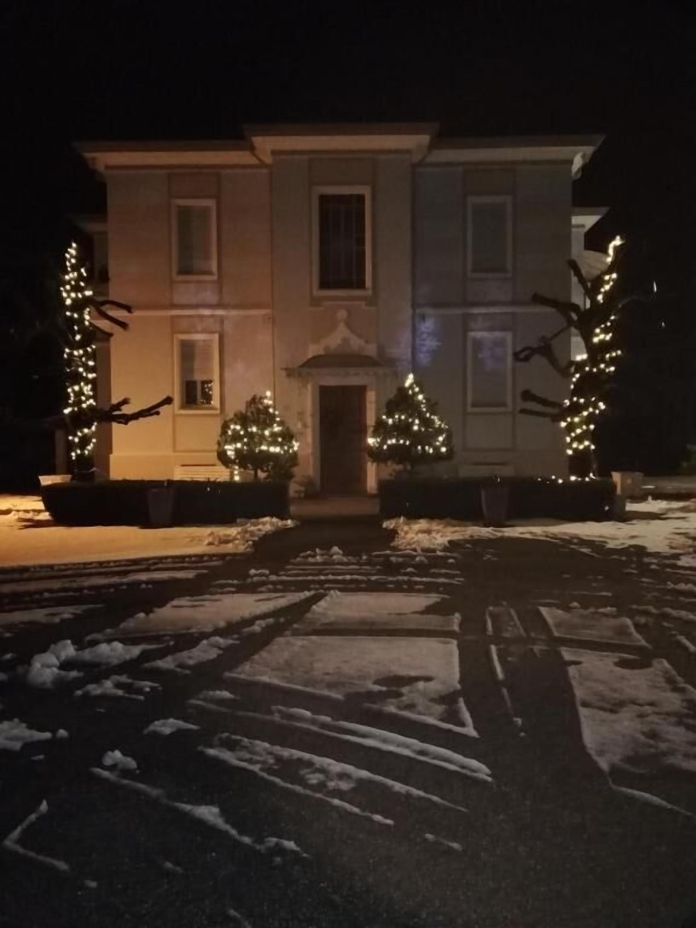 A building with a symmetrical facade, a central entrance, and snow-covered ground.