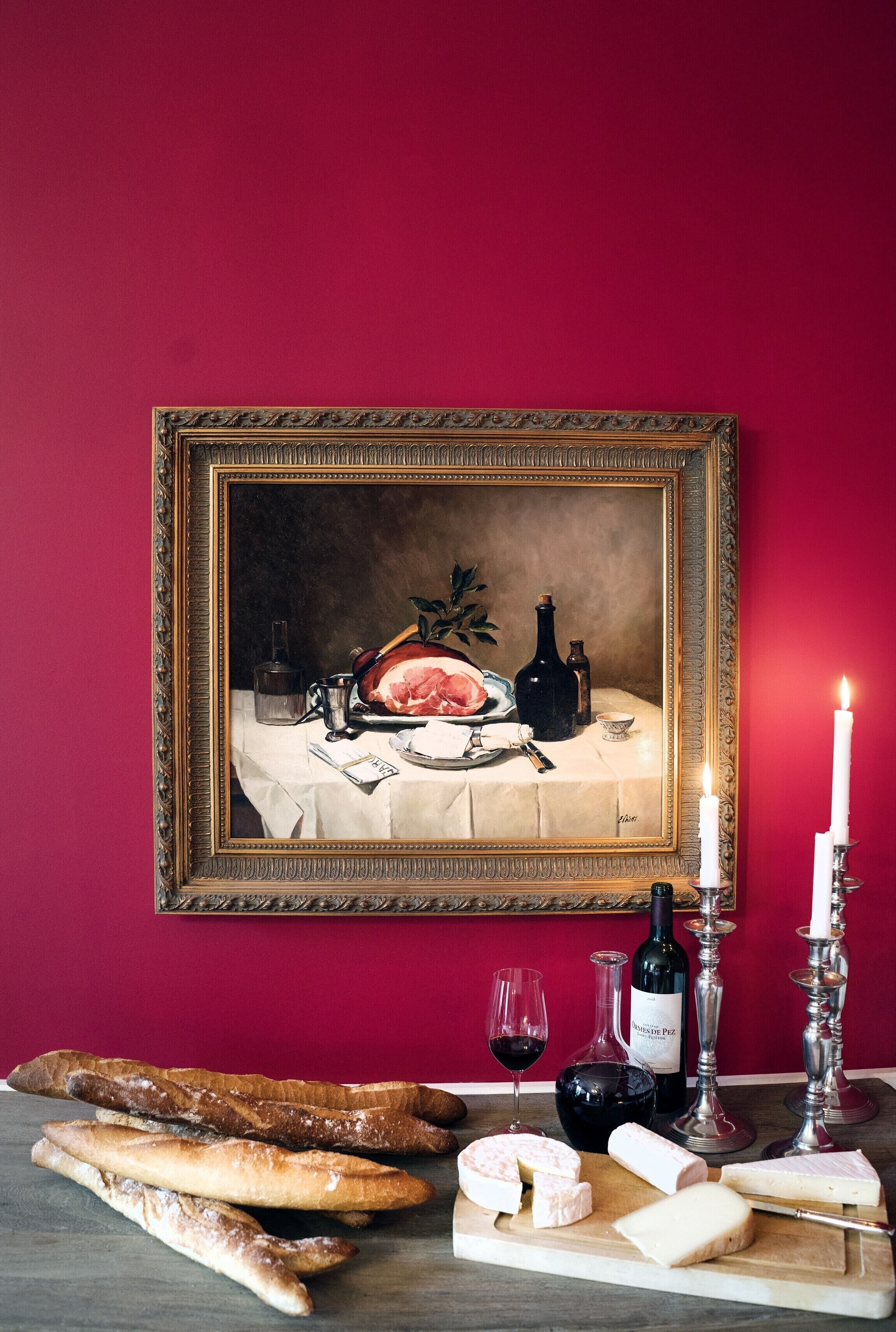 Une table avec du pain, du fromage, du vin et une bougie.