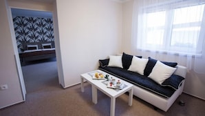 A living room with a sofa, a coffee table, and a breakfast tray. - Penzion Olomouc (Olomouc)