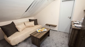 A small, cozy room with a sofa, a wooden coffee table, and a breakfast setup. - Penzion Olomouc (Olomouc)