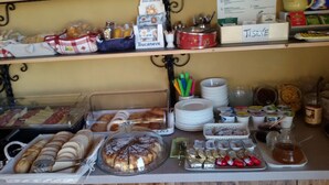 A buffet setup with various food items, including pastries, fruits, and condiments. - B&B Al Cristo (Sant'Ambrogio di Valpolicella)