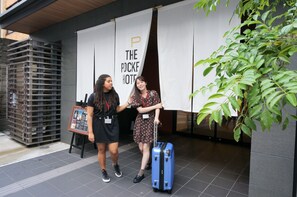 Two individuals standing in front of a building with a banner that reads "THE POCKET HOTEL." - The Pocket Hotel Kyoto Shijokarasuma (Kyoto)