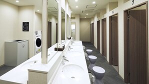 A hotel bathroom with multiple sinks, mirrors, and wooden doors numbered 1 to 7. - The Pocket Hotel Kyoto Shijokarasuma (Kyoto)