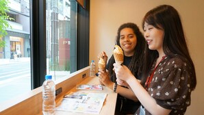 Two people sitting at a table with ice cream cones, a water bottle, and a menu. - The Pocket Hotel Kyoto Shijokarasuma (Kyoto)