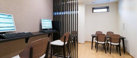A modern office space with a desk, computer, and chairs.