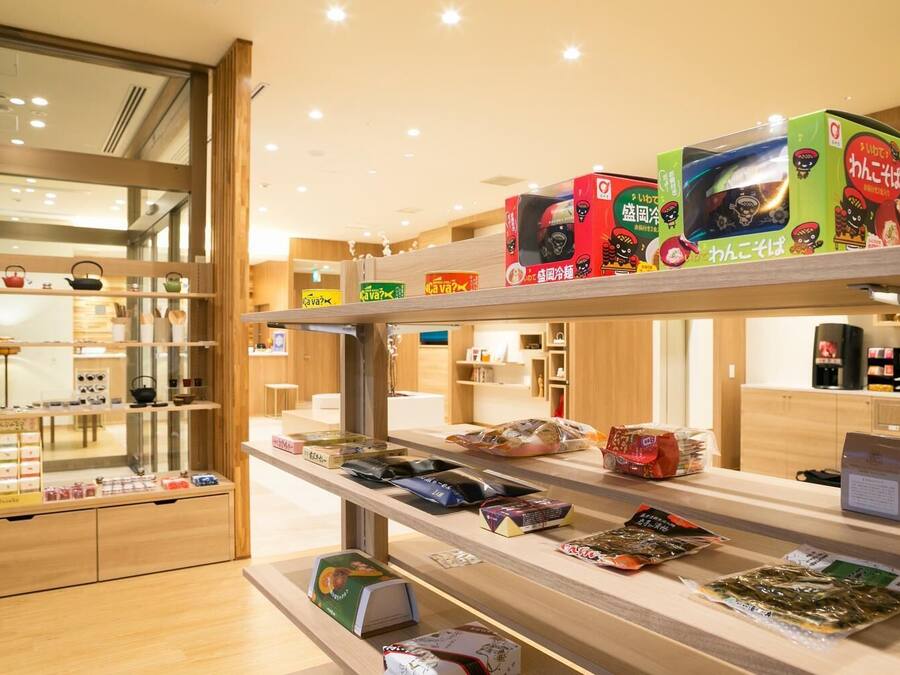 Botiga amb prestatges plens de productes envasats, incloent acompanyaments i begudes.