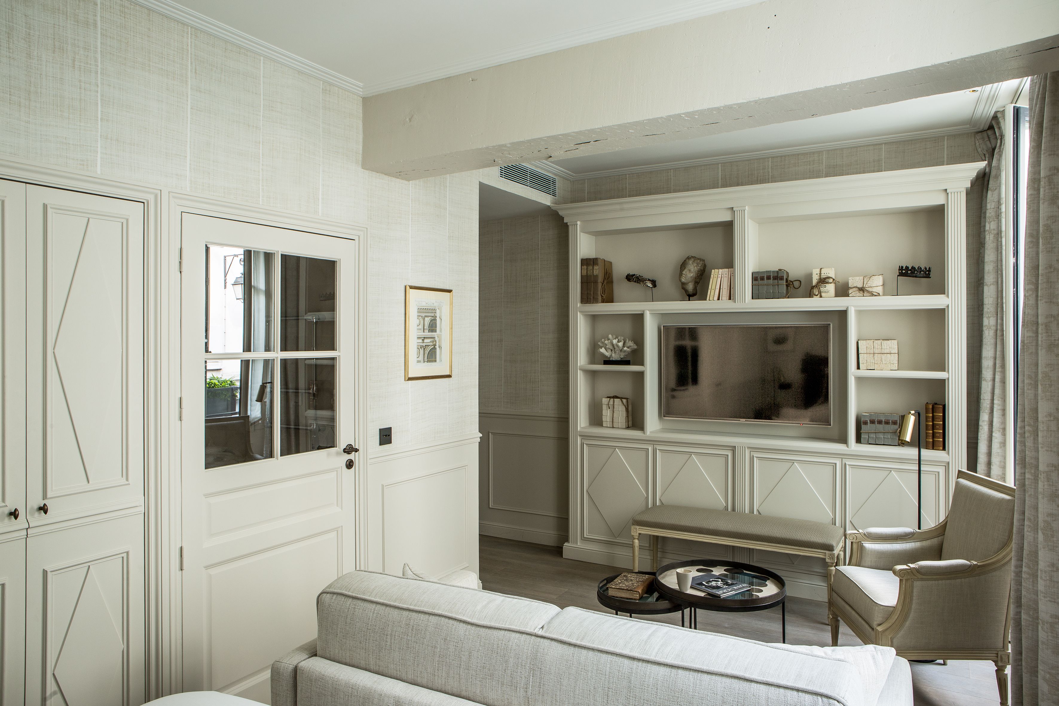 A room with a sofa, a chair, a coffee table, and a fireplace with shelves.