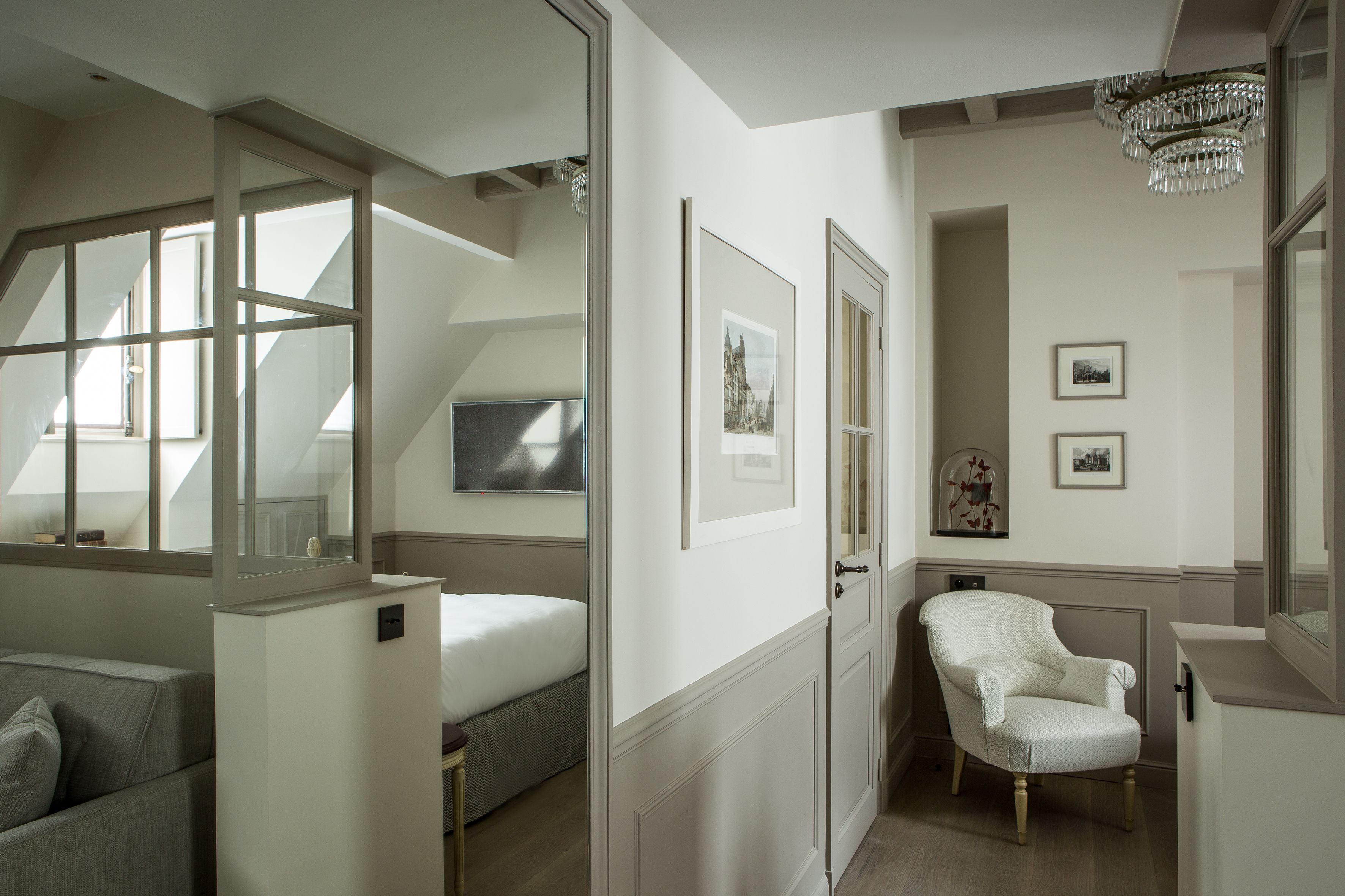 A modern bedroom with a large window, a white chair, and a bed.