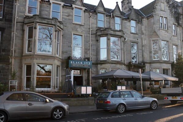 A historic stone building with a sign for 'Black Ivy' pub.