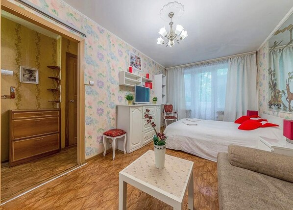 Relax in a cozy space with a neatly made bed, comfortable sofa, and ample storage.