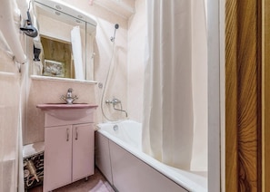 Bathroom features a bathtub, sink, and mirror.
