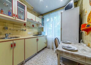 Kitchen with central island, sink, stove, and dining area for two.