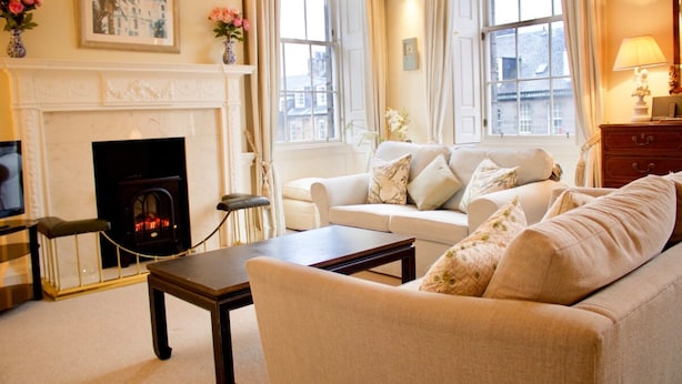 A living room with a fireplace, a sofa, a coffee table, and a television.