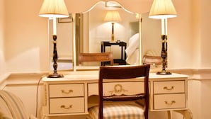 A bedroom with a wooden bed, a nightstand with a lamp, a dresser with drawers, and a mirror above the dresser.