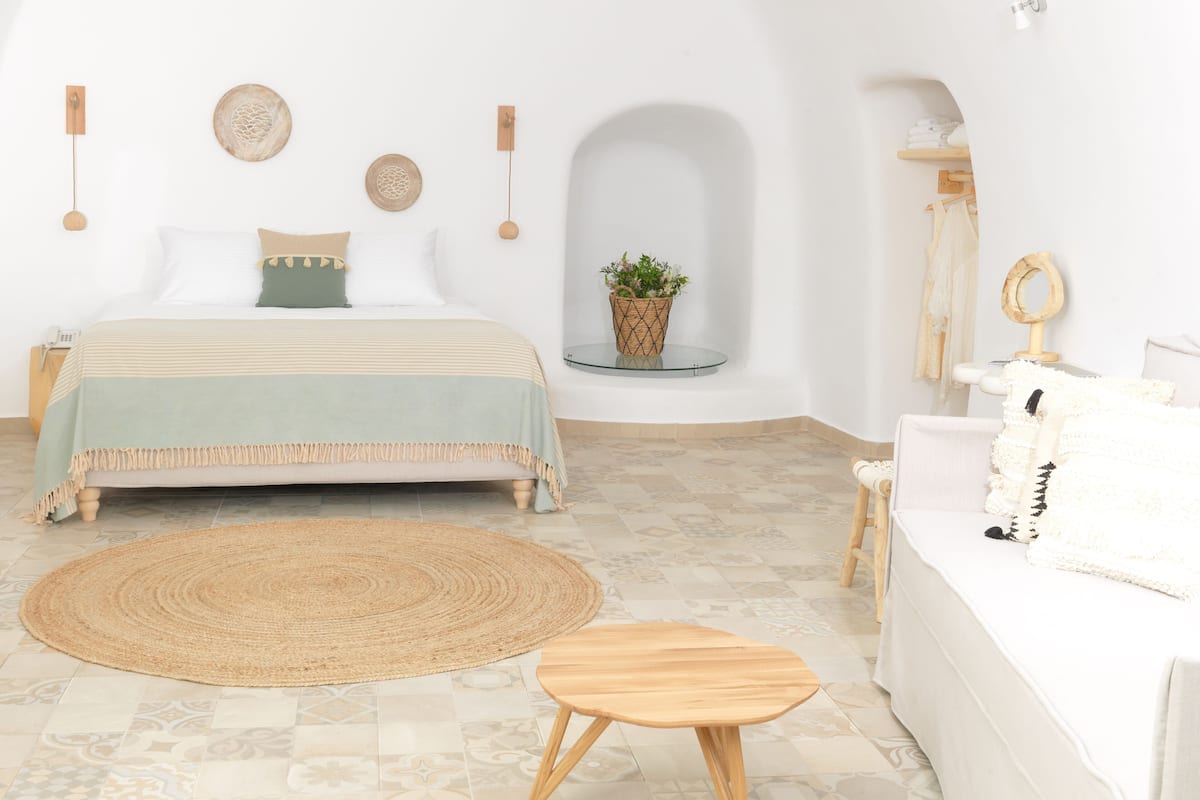 A bedroom with a bed, bedside table, and a small round table.