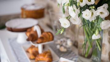 Ett bord med bakverk och en vas med blommor.