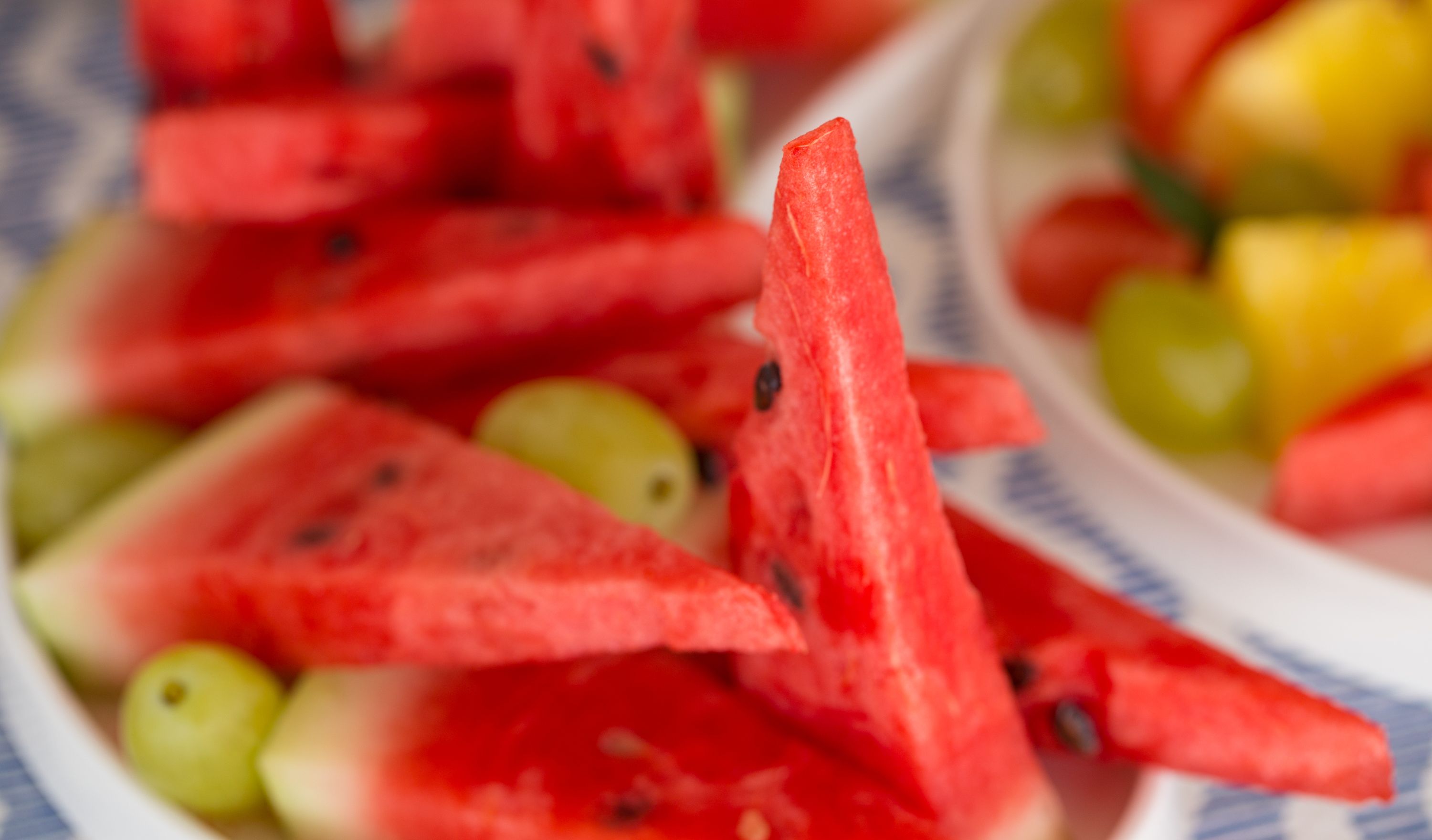 A close-up of watermelon slices and grapes on a plate.