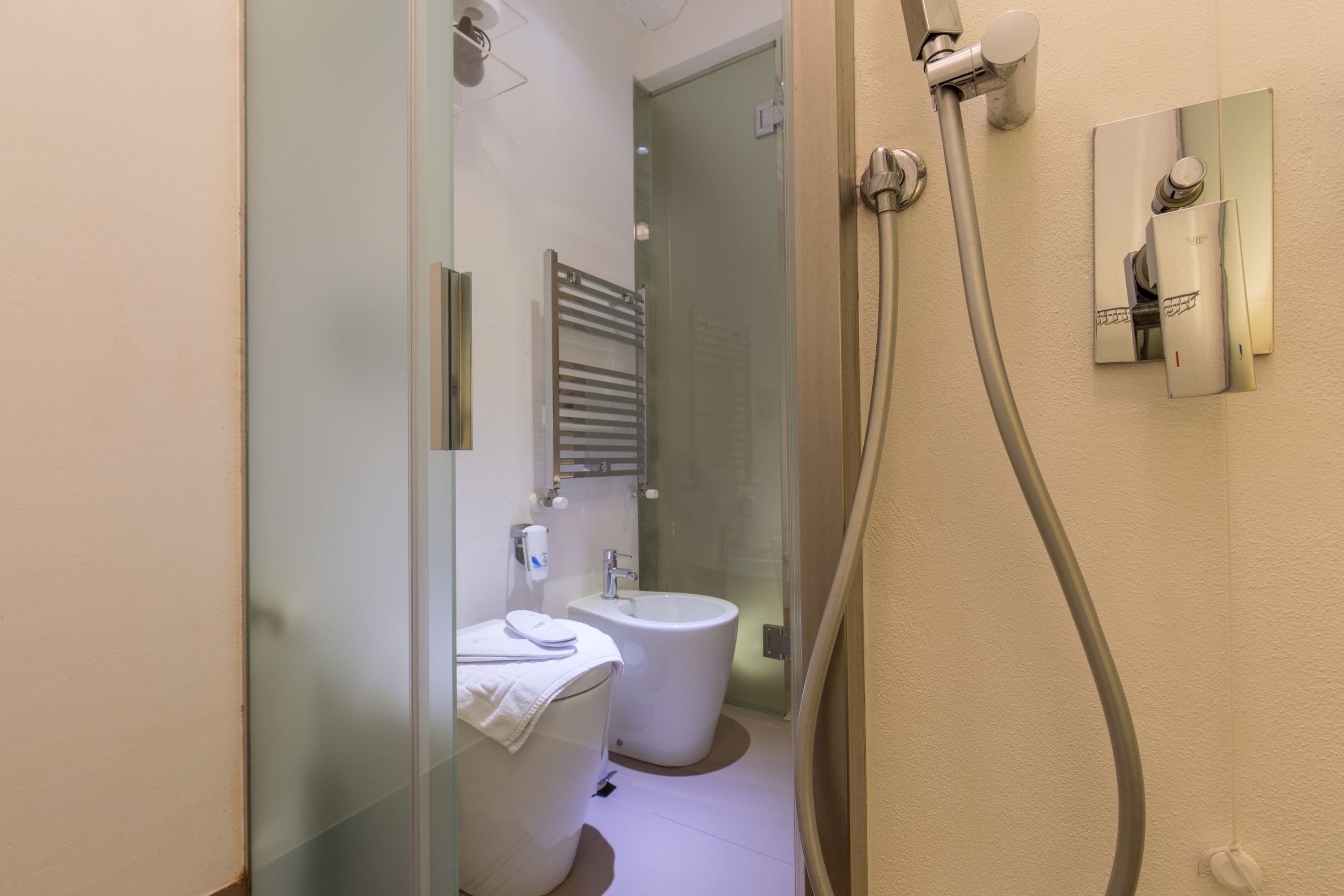 Une salle de bain moderne avec une douche à parois de verre, des toilettes et un bidet.