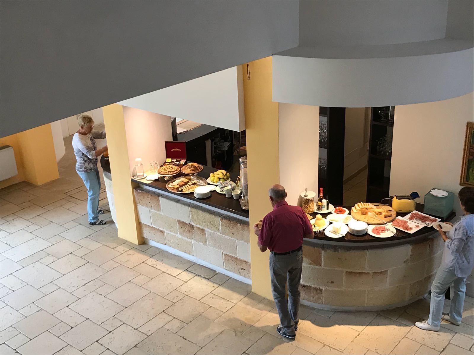 Ein Buffet mit verschiedenen Speisen und einer Person, die bedient.