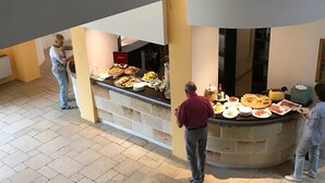 Zona de bufé con diferentes alimentos y una persona atendiendo.