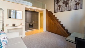 Ein modernes Interieur mit Schlafzimmer im Loft-Stil, einer Küche und einer Treppe.