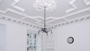 A room with a chandelier, a clock, and a fireplace. - Elforma - Barony Suite (Edinburgh)