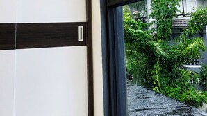 A room with a large window, a ceiling light, and a view of greenery outside. - The Sargon (Ho Chi Minh City)